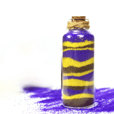 Bottle of blue, yellow, and gray layered sand art