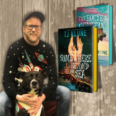 Author TJ Klune and his dog and his Cerulean Chronicles books